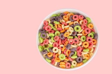 Delicious and nutritious fruit cereal loops multicolored flavorful on white background, healthy and funny addition to kids breakfast