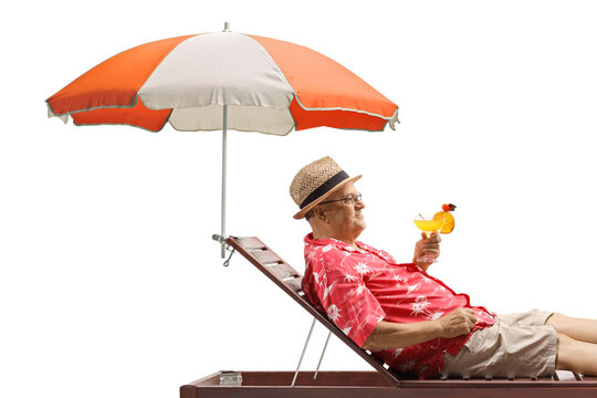 Senior tourist holding a cocktail and relaxing under umbrella