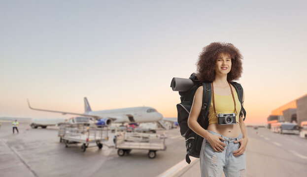 Young female traveler with a backpack standing on airport