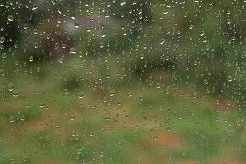 Blurred image of raindrops on glass in cloudy weather and blurry image of nature.
