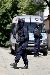 Policjant w niebieskim mundurze uzbrojony w pistolet maszynowy w czasie ćwiczeń.  - obrazy, fototapety, plakaty