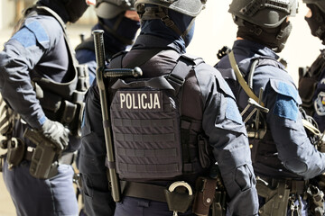 Policjant w niebieskim mundurze uzbrojony w pistolet maszynowy w czasie ćwiczeń.  - obrazy, fototapety, plakaty