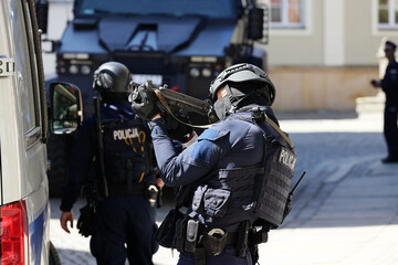Policjant w niebieskim mundurze uzbrojony w pistolet maszynowy w czasie ćwiczeń.  © FotoDax