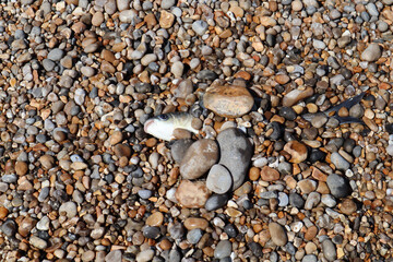 Three canoes rest on the edge of the shingle beach at the mouth of the river Axe in Axmouth
