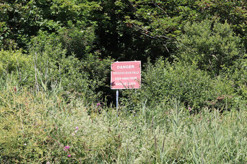 A warning sign to keep away from the cliff at Axmouth on the Jurassic coast. Rain and erosion causes frequent rock falls