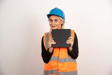 Blonde worker with notebook posing on white background