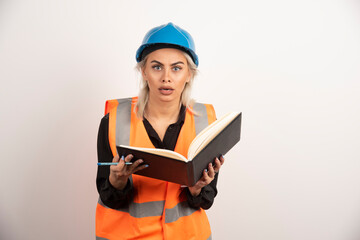 Surprised worker holding notebook on white background