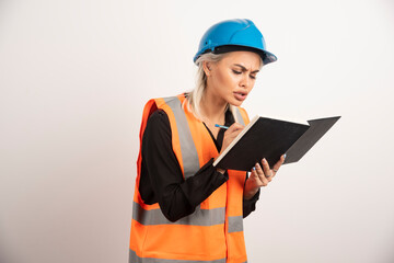 Fototapeta premium Woman construction worker writing in notebook