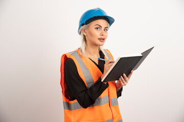 Woman construction worker writing in notebook