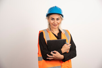 Woman construction worker standing with notebook