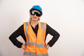 Smiling woman builder posing with goggles and helmet