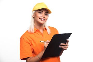 Female courier writing order on notebook on white background