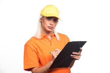 Female courier writing order on notebook on white background