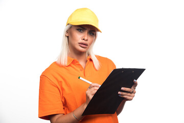 Female courier writing order on notebook on white background