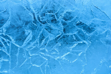 Blue cracked ice. Frozen water, sea. Frosty winter ice texture with natural cracks. Macro photography.