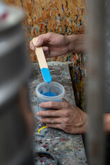 painter mixing blue color in a work area