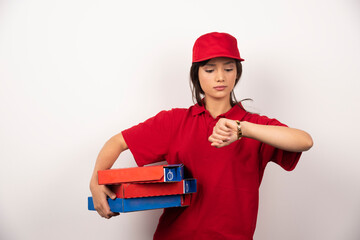 Female pizza delivery worker standing in white background with three cardboards of pizza
