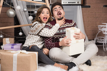 Young couple sitting on the floor in Christmas interior