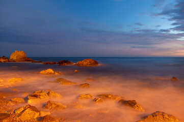 Beautiful sunset on the coast of Khao Nang Phaya, sea water hitting rocks, soft focus, Chanthaburi,...