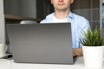 Young asian male working on laptop wearing.Remote work or education.Selective focus on laptop