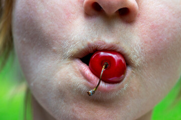 Composition of a sweet cherry and a natural hairy upper lip of a body positive young woman.