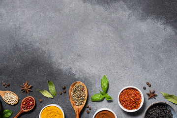 Assortment of aromatic herbs and spices on grey rustic background with copy space for your design...