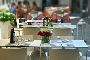 empty restaurant tables set in the terrace waiting customers for dinner