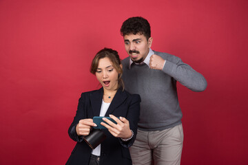 Young woman looking at phone near young man with clipboard
