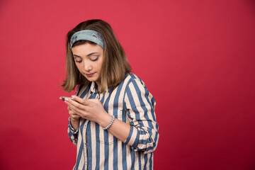 Naklejka premium Adorable girl checking messages on telephone
