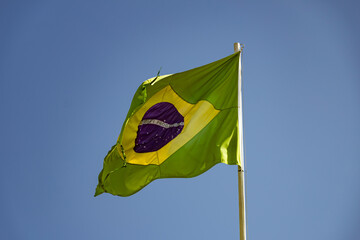 Bandeira do Brasil.
Uma velha bandeira brasileira, rasgada e desfiada, balançando ao vento.