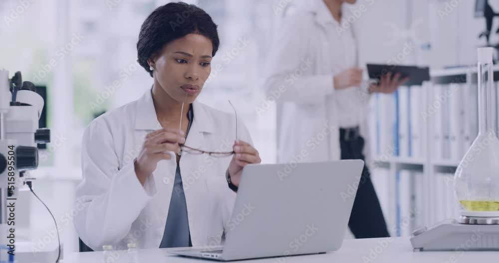 Poster stressed scientist working on a laptop in a lab. worried and unhappy woman struggling with burnout, 