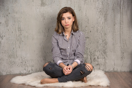 A Young Sad Woman In Plaid Shirt Blowing Her Cheeks