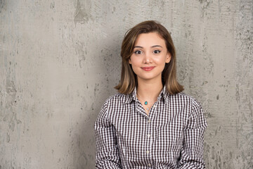 Portrait of a young smiling pretty girl in plaid shirt posing