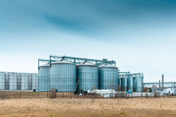 Fototapeta na wymiar Modern complex for drying,cleaning and storage a grain.Overcast blue cloudy sky spring,autumn background.