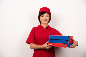 Young female pizza delivery worker holding three cardboards of pizza