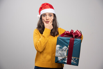 Young woman in Santa hat holding gift box