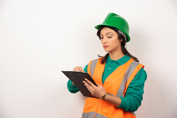 Female industrial engineer in uniform with clipboard on white background