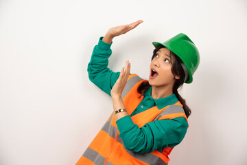 Female industrial engineer in uniform with helmet on white background