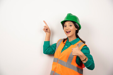 Young female construction worker on white background