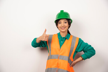 Smiling female employee with thumb up on white background