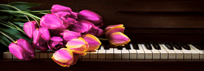 Tulips lie on the piano keys © Marina