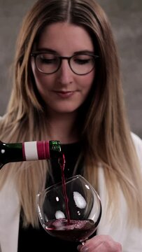 Young woman with a glass of red wine - studio photography - Vertical video