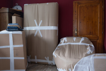 Moving home, packed furniture, cargo packaging, stock of clothes folded on the carton box