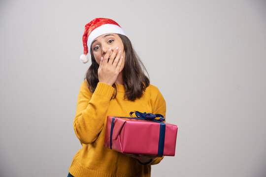 Young woman in Santa hat holding gift box