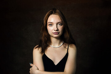 Fototapeta premium Portrait of a girl on a brown background. Gentle portrait of a young girl. Natural beauty