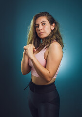Fototapeta premium woman in the gym lifting weights and posing for the camera