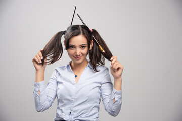 Woman artist showing her hair with paintbrushes