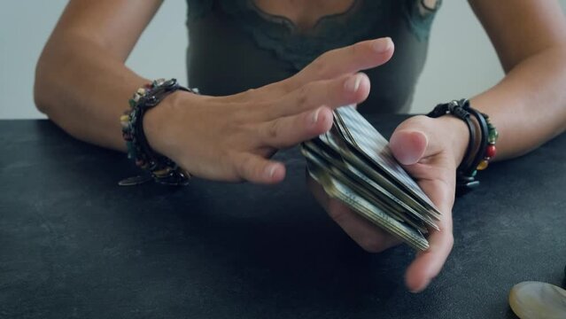 women's hands shuffle the tarot deck