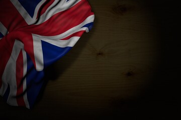 pretty national holiday flag 3d illustration. - dark picture of United Kingdom (UK) flag with large folds on dark wood with empty place for your text