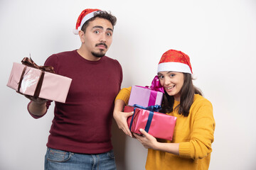 Young man with woman posing with Christmas presents
